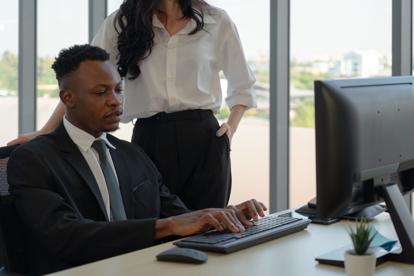 caucasian-manager-training-young-black-new-employee-to-work-with